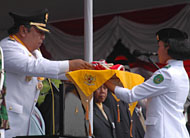 Wabup Kukar H Samsuri Aspar menyerahkan bendera Merah Putih kepada Putri Retno Utari, pelajar SMAN 2 Tenggarong