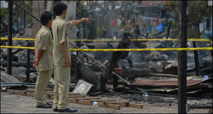 Dua orang pegawai Pemkab Kukar memperhatikan puing-puing kebakaran yang menghanguskan 41 bangunan di RT 21 Kelurahan Panji