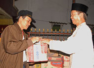 Lurah Loa Ipuh, Idris, saat menerima bantuan sembako dan uang tunai dari Pj Bupati Kukar Sjachruddin