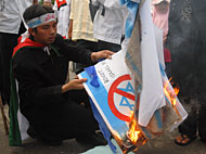 Para pengunjukrasa melakukan aksi pembakaran bendera Israel