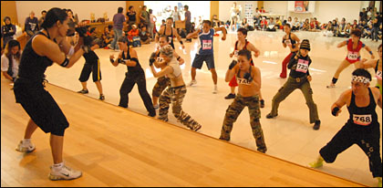Para peserta kategori Body Combat Umum mengikuti gerakan seorang instruktur di atas pentas