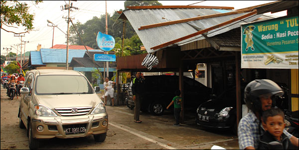 Potongan atap dari dermaga ferry tradisional Maruli Padang Raya menimpa atap rumah yang berada di seberangnya