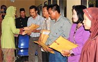 Bupati Kukar Rita Widyasari menyerahkan bantuan secara simbolis kepada perwakilan keluarga korban kebakaran di Kecamatan Tenggarong