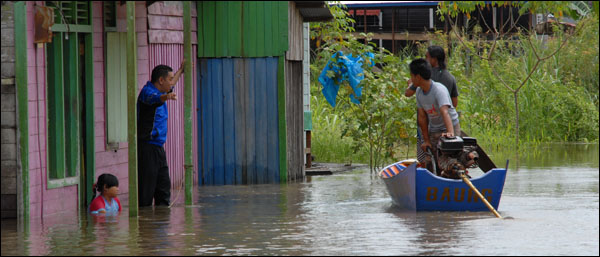 Warga di Jalan Gunung Belah, Tenggarong, menggunakan perahu ketinting setelah banjir merendam kawasan tersebut 