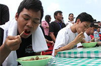 Para peserta lomba berusaha memakan pentol sebanyak-banyaknya dalam waktu 1 menit 