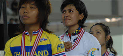Peraih medali emas nomor Omnium Elit Putri, Santia Tri Kusumah (tengah), tampak terharu saat lagu Indonesia Raya berkumandang di Velodrome Tenggarong Seberang