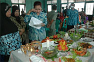 Ketua DWP Kukar Hj Dayang Telchip Suryani saat mencicipi masakan serba ikan hasil olahan peserta lomba