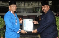 Kepala Disdukcapil Kukar Getzmani Zeth saat menerima sertifikat ISO 9001:2008 yang diserahkan Sekkab Kukar Edi Damansyah