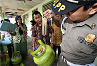 Disaksikan Sekretaris Disperindakop Abidinsyah Kadrie, seorang anggota  Satpol PP menimbang tabung elpiji ukuran 3 kg