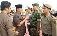 Wabup Kukar HM Ghufron Yusuf menyematkan pita tanda Operasi Lilin 2013 kepada perwakilan anggota TNI
