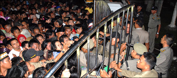 Petugas Satpol PP Kukar menjaga pintu gerbang untuk membatasi warga yang hendak masuk ke halaman Pendopo Odah Etam