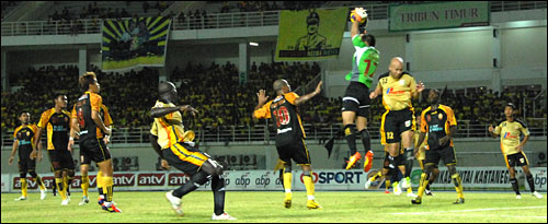 Kiper Sriwijaya FC Ferry Rotinsulu dengan sigap mengamankan bola di daerah pertahanannya