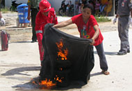 Salah seorang warga Desa Gas Alam tampak berhati-hati memadamkan kompor terbakar dengan menggunakan selimut basah