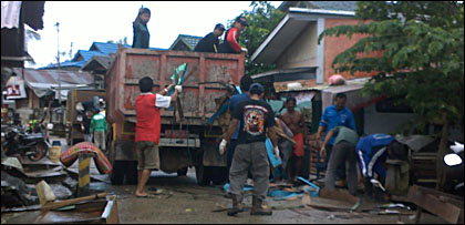 Warga Muara Badak bahu-membahu membersihkan sampah yang berserakan di jalan pasca terjadinya banjir