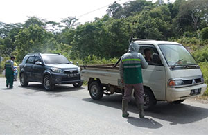 Anggota relawan di desa Lebak Cilong menyemprotkan disinfektan ke kendaraan yang memasuki Muara Wis serta mendata orang yang akan masuk wilayah mereka 