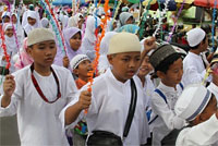 Para pelajar dengan berbusana Muslim mengikuti pawai dengan penuh semangat