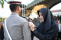 Bupati Rita Widyasari secara simbolis memasang pita Operasi Ketupat kepada perwakilan anggota Polri