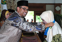 Ketua Dewan Pendiri & Pembina Yayasan Nurul Ilmi HM Ali Hamdi ZA memasangkan medali wisuda kepada salah seorang lulusan PGTKI Nurul Ilmi