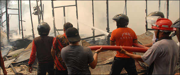 Petugas PMK dibantu warga berupaya memadamkan sisa api yang masih berkobar