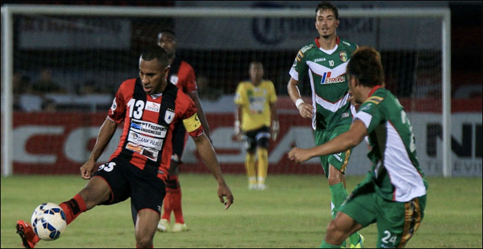 Kapten tim Persipura Ian Louis Kabes mengambil bola dibayang-bayangi bek Mitra Kukar Michael Orah. Dalam laga ini, Mitra Kukar menyerah 1-0 dari Persipura Jayapura