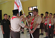 Asmara Diharja dari Kwarcab Kukar menyerahkan bendera Pramuka kepada Achmad Solihin selaku pimpinan kontingen