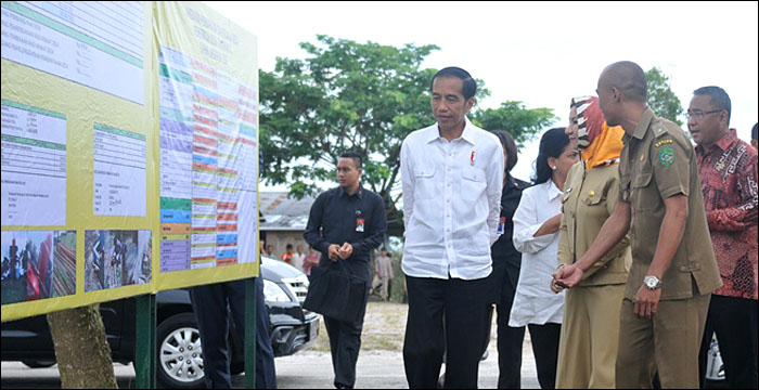 Presiden Joko Widodo memperhatikan papan informasi hasil pembangunan di desa Tani Bhakti yang memanfaatkan ADD APBN 2016