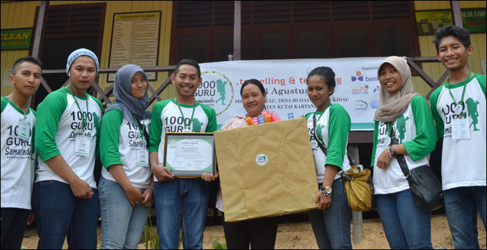 Para relawan program Traveling and Teaching 1000 Guru menyerahkan bantuan kepada Norya selaku Kepala SDN 026 Lekaq Kidau