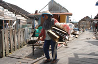 Seorang pemulung mengumpulkan barang-barang bekas yang tersisa dari rumah warga Tanjong yang telah dibongkar