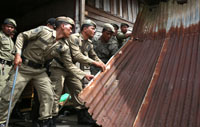 Petugas Satpol PP Kukar melepas bagian teras rumah yang telah dirobohkan