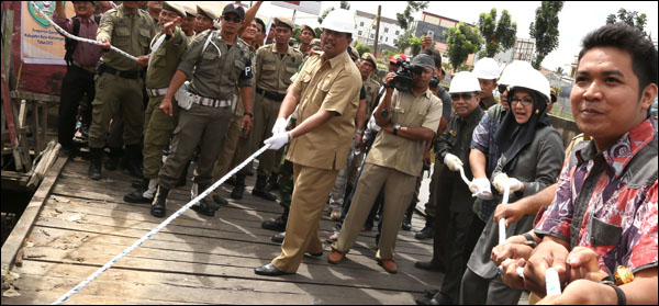 Bupati Rita Widyasari bersama pejabat lainnya dan perwakilan pemilik rumah (kanan) secara simbolis memulai pembongkaran pemukiman Tanjong dengan merobohkan teras sebuah rumah