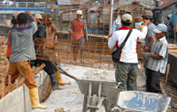 Para pekerja memasang rangkaian kawat besi sebelum dilakukan pengecoran <i>jogging track</i>