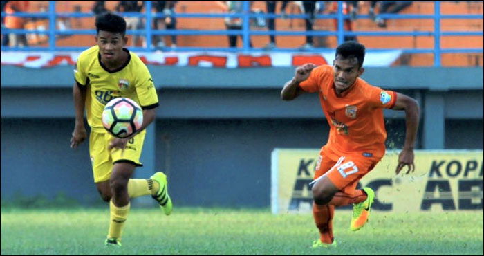 Gelandang Mitra Kukar U-19 Delan Selang (kiri) berupaya menggiring bola ke arah pertahanan Borneo FC U-19 
