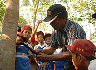 Ketua Kelompok Tani Wonomulyo, Zakaria, memperagakan cara menoreh batang pohon karet