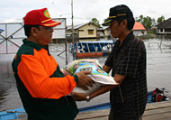 Kepala Badan Kesbang Linmas Kukar H Darmansyah menyerahkan bantuan sembako secara simbolis untuk korban banjir
