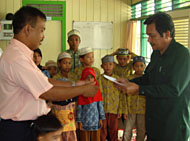 Ketua BAZ Kukar Alimuddin Mandu (kanan) menyerahkan bantuan dana kepada pimpinan Ponpes/PA Mishbahun Munir