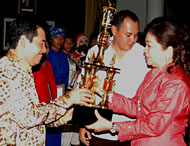 Ny Hj Dayang Kartini Syaukani menyerahkan piala Juara Umum kepada Kepala BPKD Kukar Drs HM Hardi MM