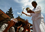Salah seorang pemangku memercikkan air suci kepada umat Hindu Dharma usai ritual persembahyangan