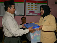 Ketua GOPTKI Kukar Hj Anna Husni Thamrin (kanan) menyerahkan bantuan alat permainan kepada pimpinan TK Raudhatul Khair, Kelurahan Loa Tebu, Tenggarong
