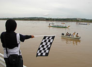 Seorang petugas bersiap mengangkat bendera start dalam Lomba Dayung Perahu Naga dalam rangka HUT KORPRI ke-35