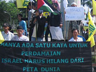 Para pengunjukrasa membentangkan spanduk kecaman terhadap Israel