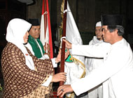Asisten III AR Ruznie Oms (kanan) ketika menyerahkan secara simbolis pataka berlambang Kabupaten Kukar kepada Rahmawati dari TKHI