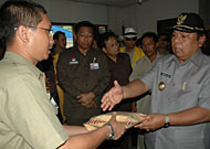Wabup Kukar H Samsuri Aspar (kanan) saat menyerahkan bantuan Pemkab Kukar kepada camat Loa Janan