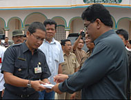 Sekkab HM Aswin (kanan) menyerahkan bantuan kepada Camat Loa Janan Dafip Haryanto