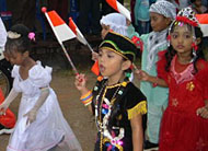 Bocah TK dengan mengenakan busana daerah melintasi panggung kehormatan sambil menyanyikan lagu <i>Hari Merdeka</i>