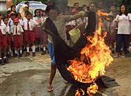 Seorang ibu rumah tangga tengah mencoba mengatasi kompor yang terbakar
