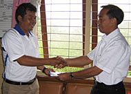 Kepsek SDN 031 Darjat AMPd menerima bantuan secara simbolis dari Kepala Kancatel Tengarong Zulpan Wadhana