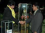 Bupati Kukar H Syaukani HR (kiri) menyerahkan Piala Bergilir Bupati Kukar kepada Ketua Kafilah Muara Jawa selaku Juara Umum MTQ ke-28