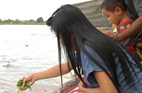 Sumarni didampingi putranya yang masih balita diberi kesempatan untuk menabur bunga pertama kali