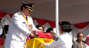 Noor Izzatil Hasanah yang mendapat kepercayaan untuk menerima bendera dari Bupati Kukar H Syaukani HR