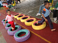 Dua bocah beradu cepat melintasi rintangan ban